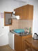 Kitchenette with sink, fridge and cupboards